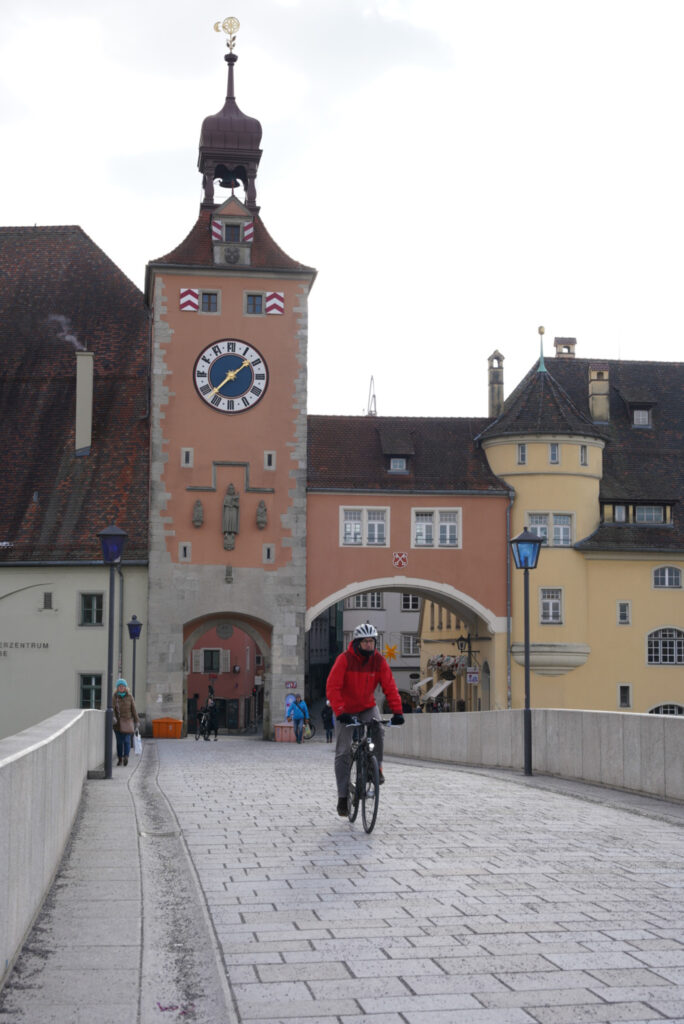 A biker going across the stone bridge at Regensburg, Germany, photo by Alex Lau