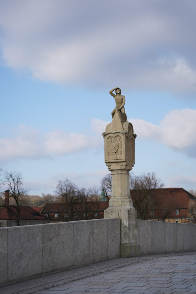 Bruckmandl statue at the highest point of the stone bridge at Regensburg, Germany, photo by Alex Lau