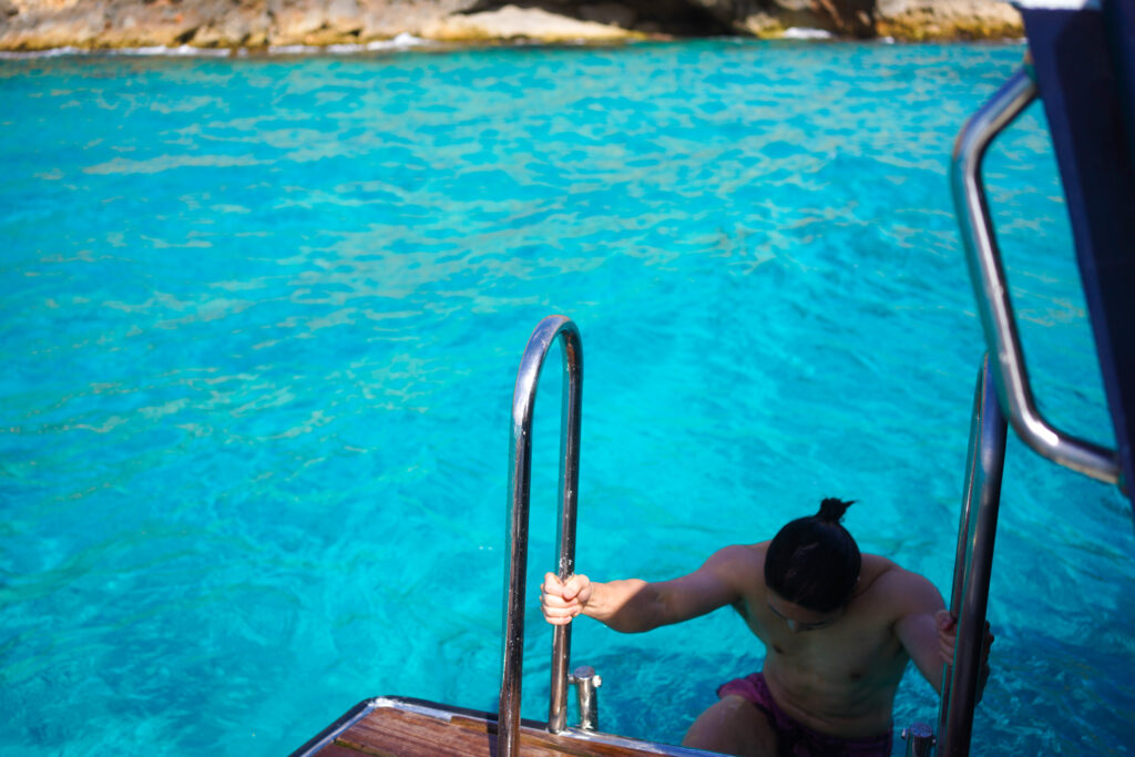 Diving into the water during Palma Bay Boat Tour and Snorkel in Spain by Sa Calma Boats, photo by Alex Lau